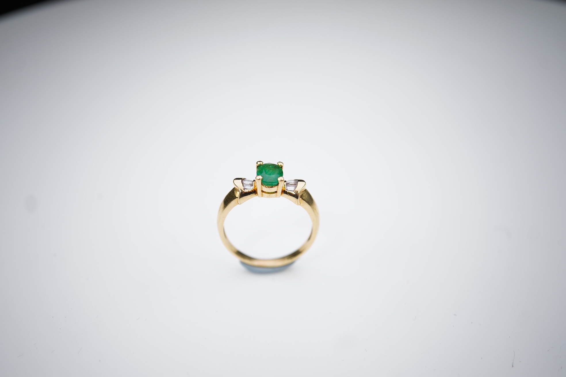 An emerald and diamond ring
